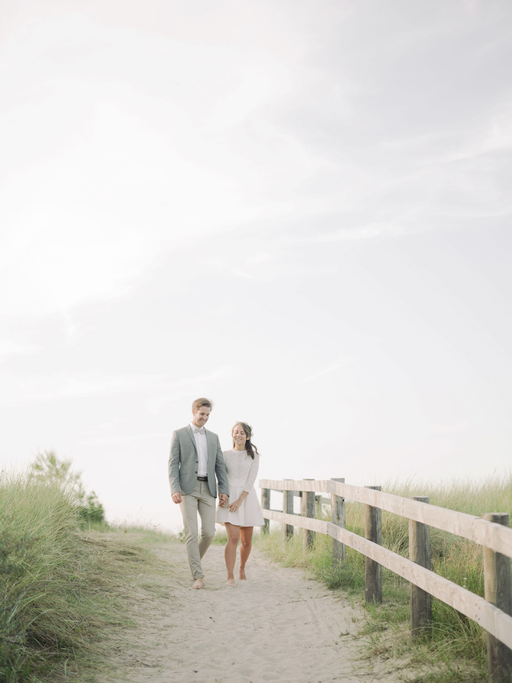 Un couple marche sur le bord de mer main dans la main